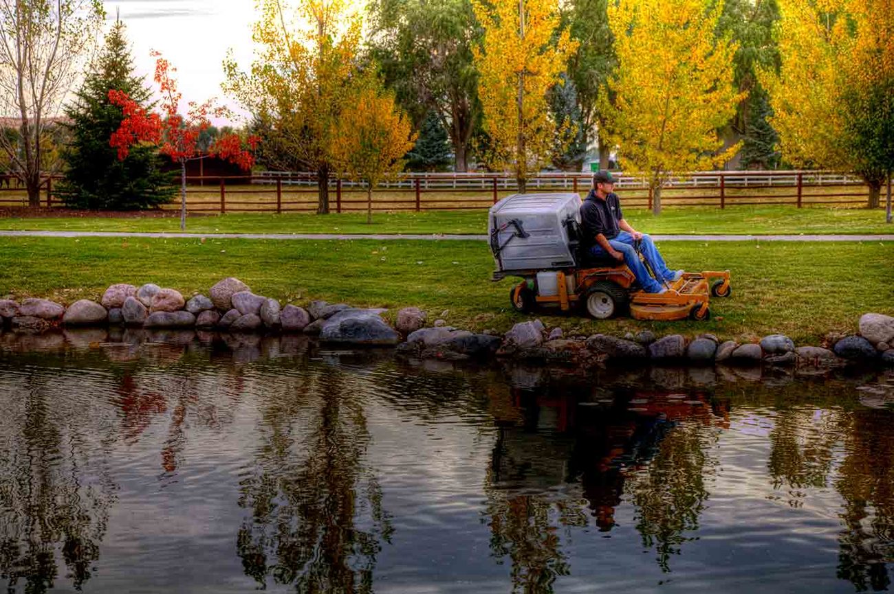 Grounds technician mowing a landscaped property