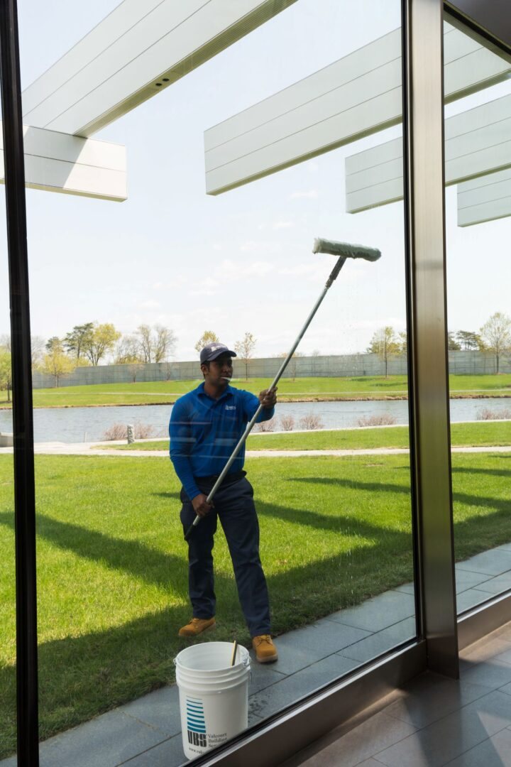 TMG technician washing exterior windows